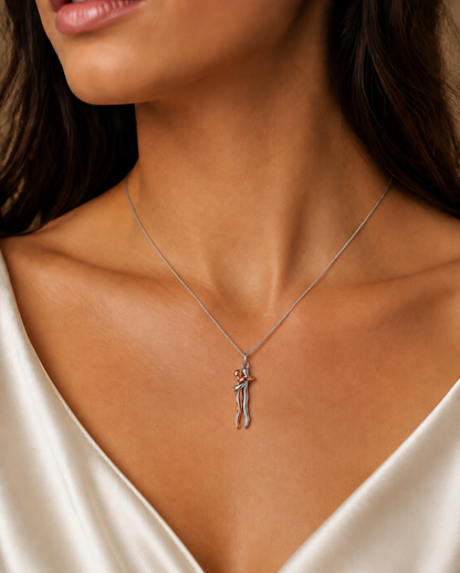 Close-up of the Forever Hug pendant showing the two embracing figures in gold and silver